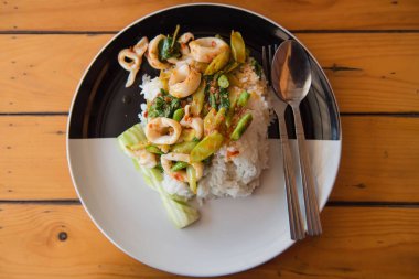 Tavada kızartılmış kalamar ve fesleğen plaka ile tepesinde pirinç 