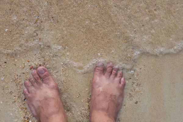 Vista superior e pés humanos na areia e ondas mar no verão — Fotografia de Stock