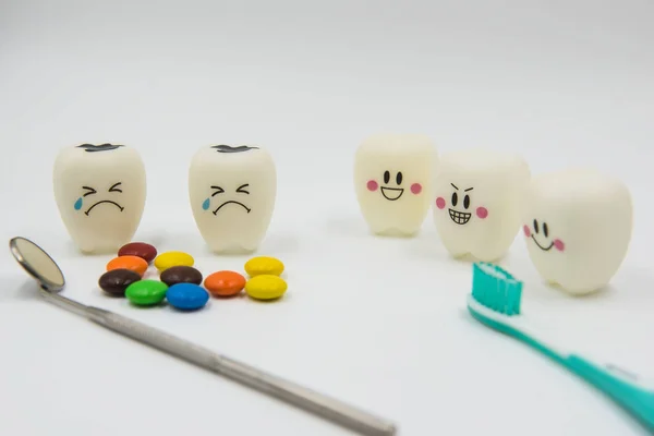 Modelo Lindos juguetes dientes y dulces de colores en la odontología sobre un fondo blanco — Foto de Stock