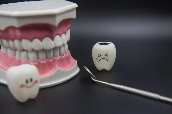 Modelo Bonito brinquedos dentes na odontologia em um fundo preto — Fotografia de Stock