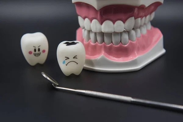 Modelo Lindos juguetes dientes en odontología sobre un fondo negro — Foto de Stock