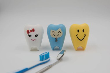 Diş Hekimliği beyaz bir arka plan üzerinde renkli modeli sevimli oyuncaklar dişlerde