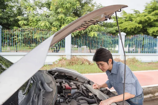 Kadın yalnız kırsal bir yolda arabasını tamir