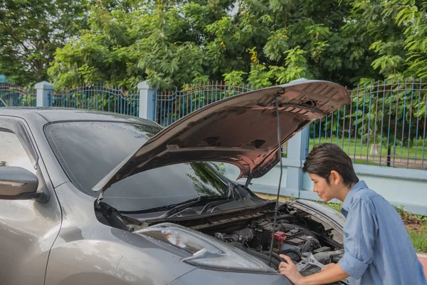 stock image car is broken on the country road and woman was repairing his car