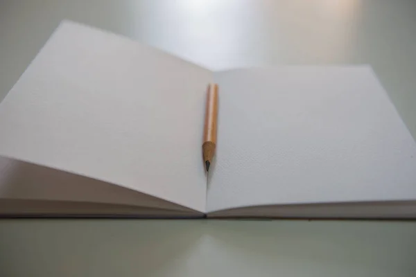 Lápices en el libro blanco sobre la mesa — Foto de Stock