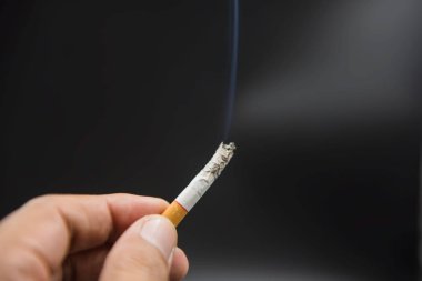 Siyah arka plan üzerine elinde Sigara 