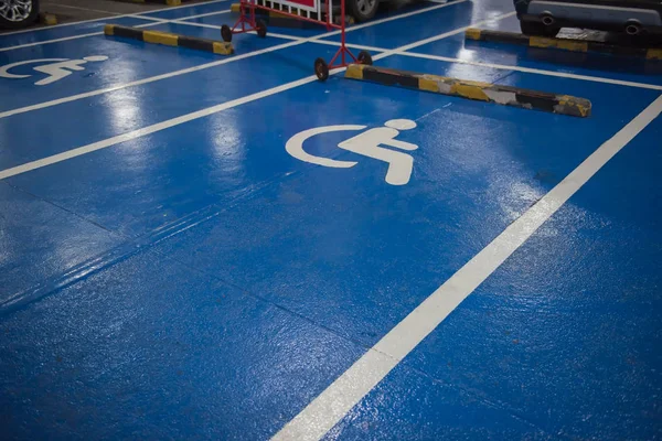 Bianco e blu Handicap simbolo parcheggio auto di disabili sul pavimento — Foto Stock