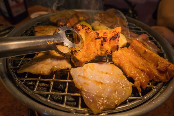 Carne a la parrilla sobre la estufa de carbón caliente —  Fotos de Stock
