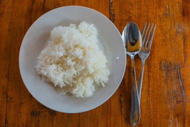 Bir tabak ve kaşık masa arka plan üzerinde pişmiş pirinç