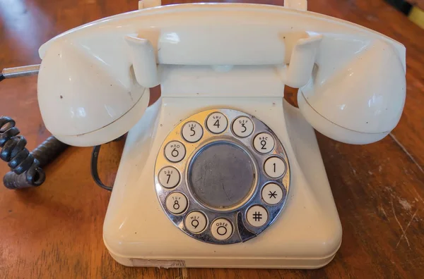Primer plano Vintage teléfono blanco sobre un fondo de mesa de madera — Foto de Stock