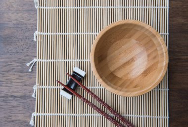 Ana sayfa görünümü tahta çubuk üzerinde bambu hasır ahşap masa üzerinde bir kase 