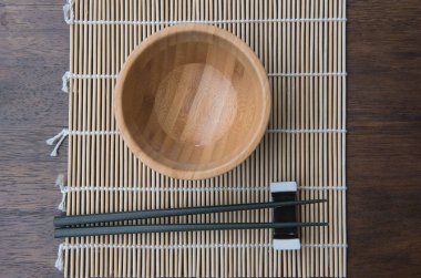 Ana sayfa görünümü tahta çubuk üzerinde bambu hasır ahşap masa üzerinde bir kase 