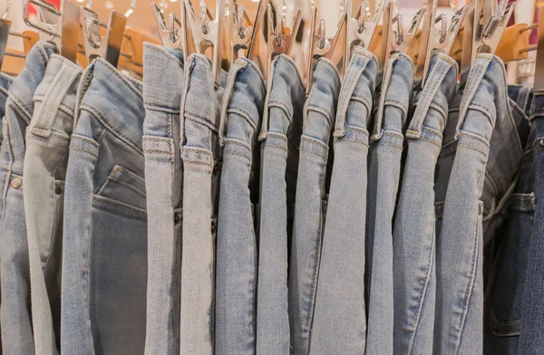 Muitos jeans azuis no rack na loja para venda — Fotografia de Stock