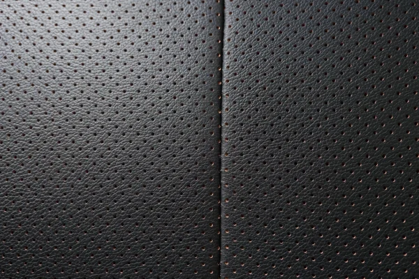 Closeup perforated artificial black leather background texture — Stock Photo, Image