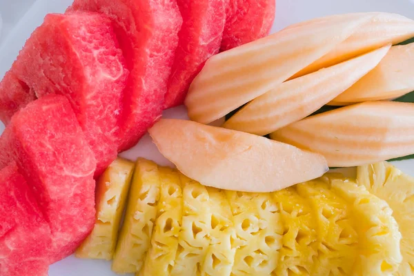 Primo piano Frutta tropicale fresca, ananas, melone e anguria su un piatto — Foto Stock