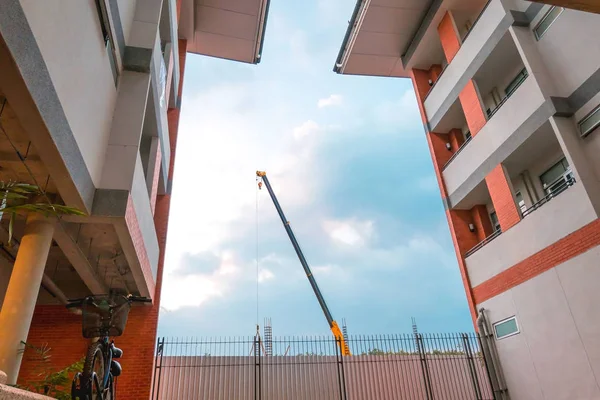 城市和蓝天背景下的起重机建筑砖建筑 — 图库照片