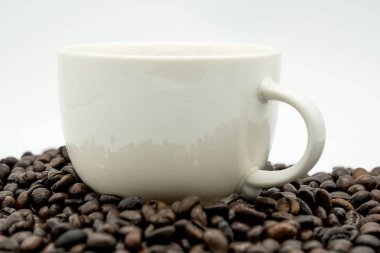 Beyaz kahve fincanı ve kahve çekirdekleri beyaz arka plan üzerinde izole .