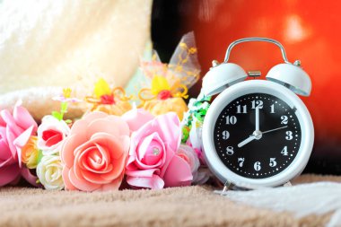 Küçük çalar saat ile masaya güzel çiçek