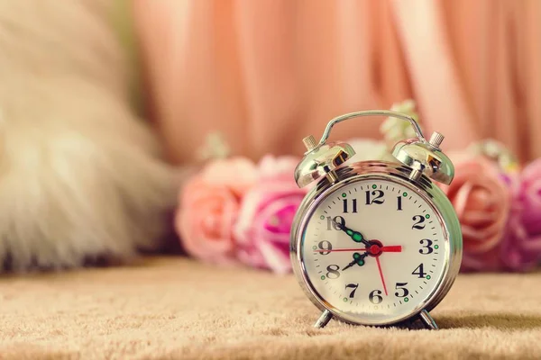 Pequeño reloj despertador con hermosas flores en la mesa estilo vintage —  Fotos de Stock