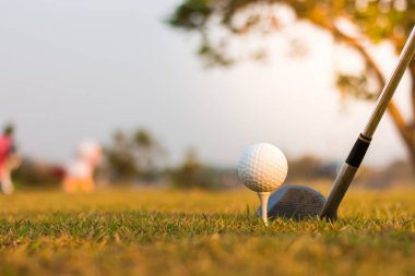 Golf topu beyaz tee ve golf club atış hazırlanıyor.