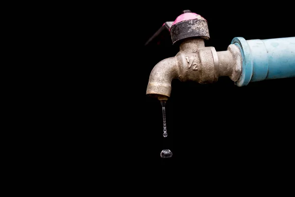 Stary zardzewiały wody wycieka izolować na czarnym tle — Zdjęcie stockowe