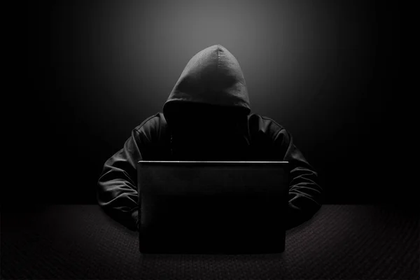 Hacker de computador com capuz roubando informações com laptop — Fotografia de Stock