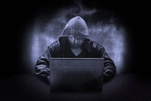 Hooded computer hacker stealing information with laptop — Stock Photo, Image