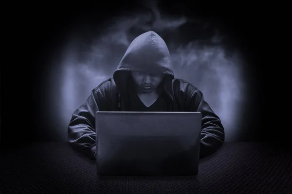 Hooded computer hacker stealing information with laptop — Stock Photo, Image