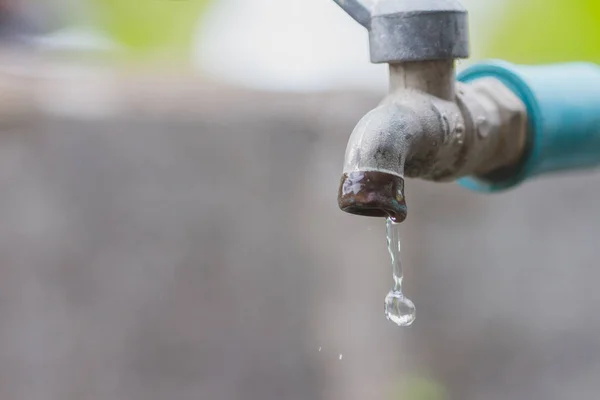 Кран с каплей воды / концепция потребления воды — стоковое фото