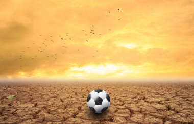 Futbol topu Kuru toprak günbatımı üzerinde