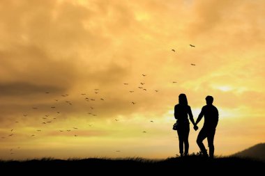 bir erkek ve kadın gün batımı sırasında siluetleri