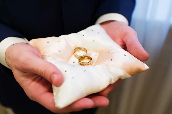 Groom holding wedding rings — Stock Photo, Image