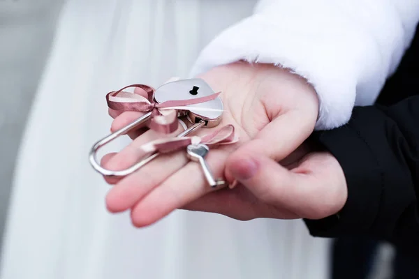 Nevěsta a ženich s visacím zámkem lásky s klíči — Stock fotografie