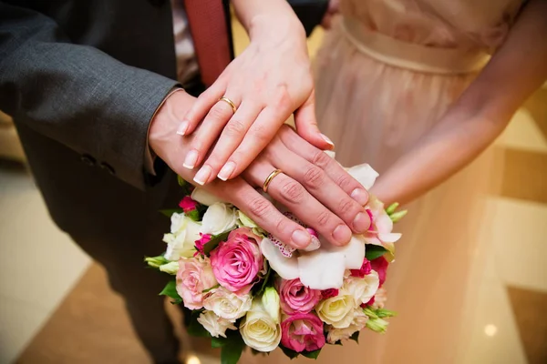 Handen van de bruid en bruidegom met de gouden ringen — Stockfoto