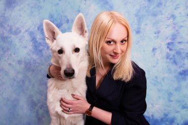 Güzel genç kadın ile mavi zemin üzerine beyaz köpek