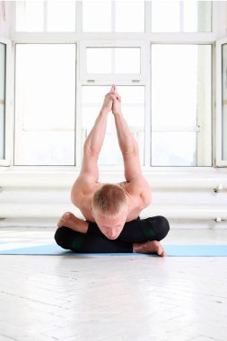 Sportif adam pratik Yoga büyük pencere ile beyaz odada