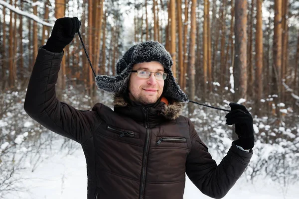 Человек в меховой зимней шляпе с ушными закрылками улыбающийся портрет — стоковое фото