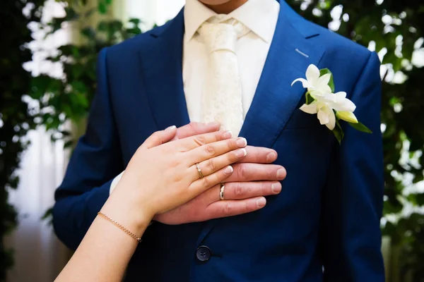 Casamento boutonniere em terno de noivo e noivas mão — Fotografia de Stock