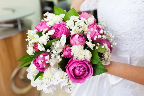 Bruden håller vackra bröllop bukett med rosa rosor — Stockfoto