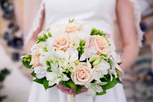 Beautiful wedding bouquet of flowers in brides hands
