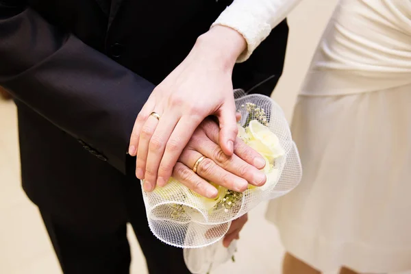 Ženich a nevěsta s prsteny a svatební kytice — Stock fotografie