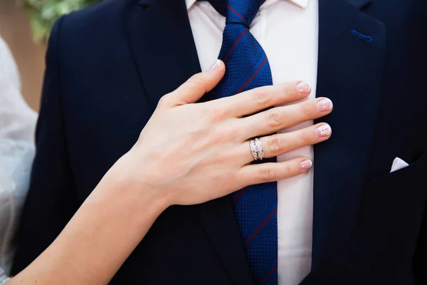 Suit of groom and brides hand — Stock Photo, Image