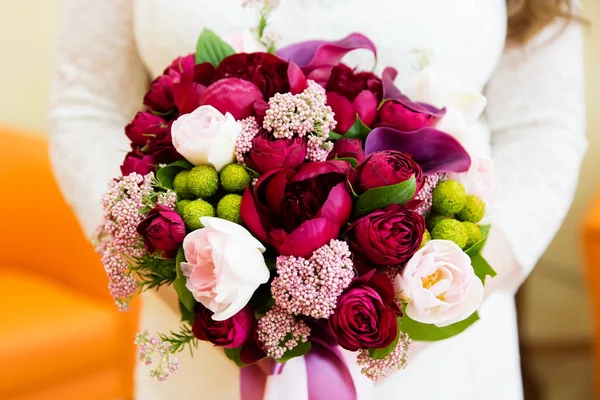 Свадебный букет цветов и обручальных колец в руках невесты — стоковое фото