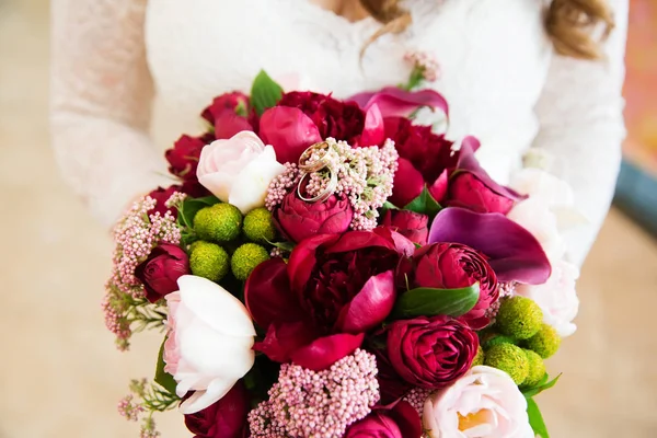 Ramo de flores y anillos de compromiso en las manos de la novia — Foto de Stock