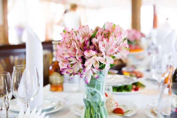 Mesa servida en el restaurante con composición floral —  Fotos de Stock