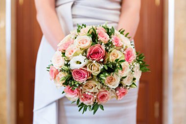 Gelinin elinde bir buket çiçek.