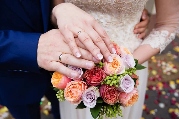 結婚指輪と美しいブライダル ブーケと新郎新婦の手 — ストック写真