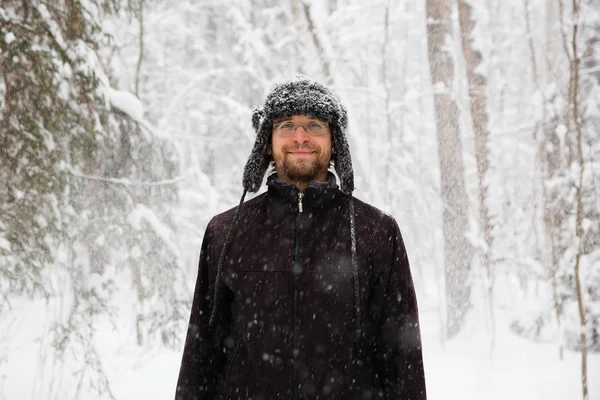 Человек Меховой Зимней Шляпе Ушными Закрылками Улыбается Портрет Лесу — стоковое фото