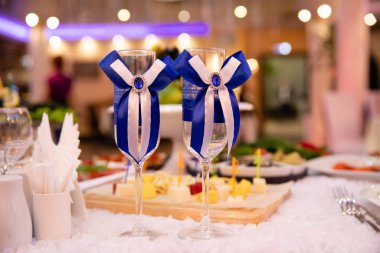 Beyaz ve mavi kurdeleli iki düğün kadehi.