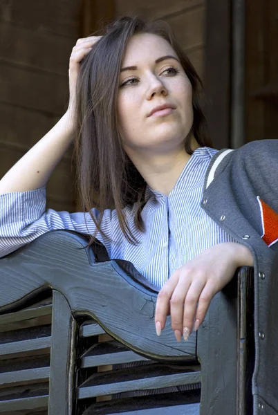 Молодая девушка с длинными волосами в рубашке и толстовке смотрит в сторону , — стоковое фото